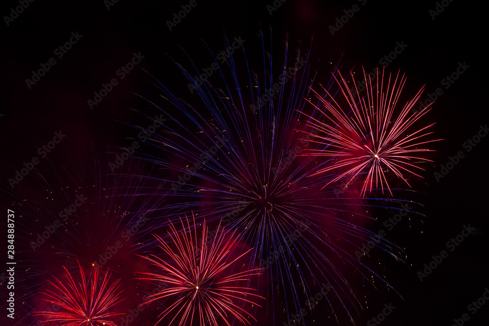 Red and blue festive fireworks on a black background. Abstract holiday background. International Fireworks Festival ROSTEC