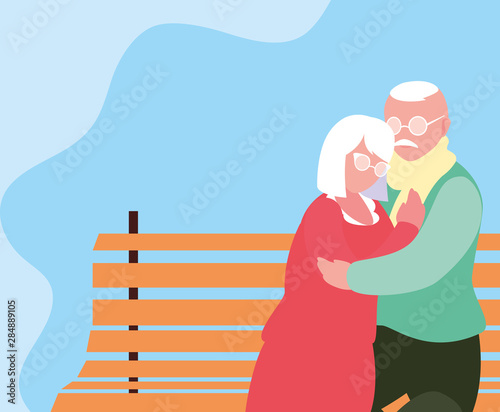 cute old couple seated in chair of park