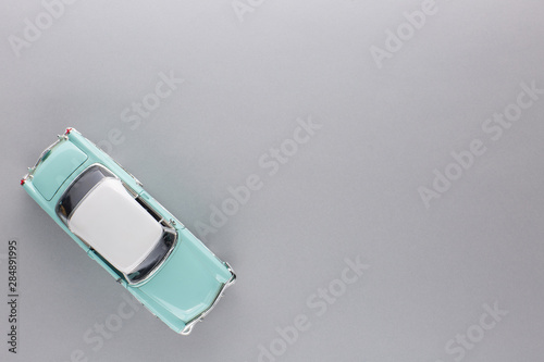 A light blue car figurine, shot from above.