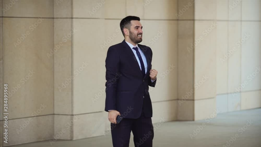 Handsome millennial businessman celebrating and silly goofy dancing directly into the camera celebrating his achievement and success Handsome millennial businessman celebrating and silly goofy dancing directly into the camera celebrating his achievement and success