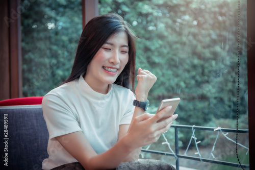 beatiful asian girl s holding mobile and have emotion happy looking at mobile phone