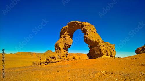 Arch Rock formation aka Arch of Africa or Arch of Algeria with moon at Tamezguida in Tassili nAjjer national park in Algeria