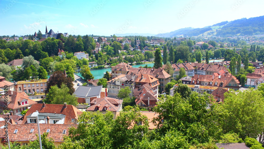 View on Bern with the turquoise river Aare, the Dalmazibrucke and houses with characteristic red roofs, in summer 2019