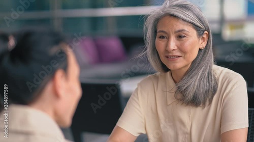 Two Women Are Sitting And Speaking At The Office