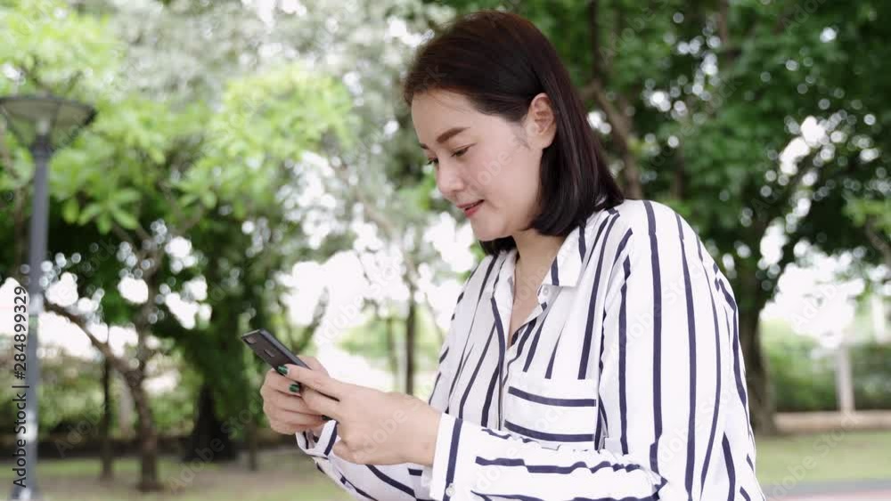 Women playing, chat, or playing game on mobile smartphone at the park. Women playing, chat, or playing game on mobile smartphone at the park.