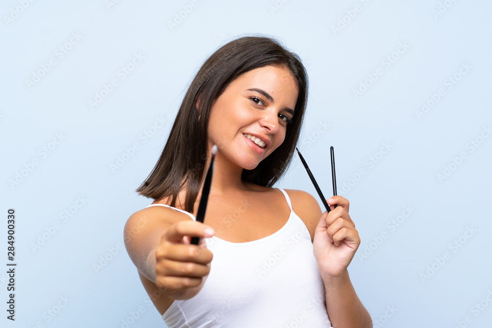 Young girl holding a lot of makeup brush Young girl holding a lot of makeup brush