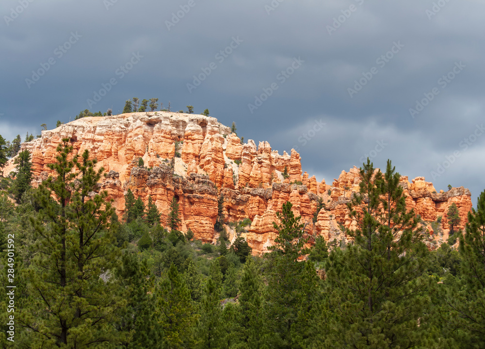 Stout Canyon red and white sandstone hoodoos with thunder clouds in Utah