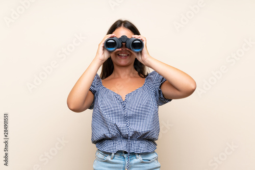 Young girl over isolated background with black binoculars