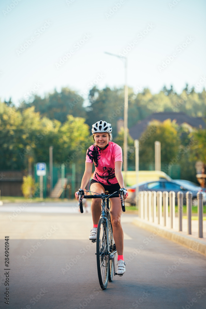 Fototapeta premium Picture of young woman in helmet on bike ride on summer day