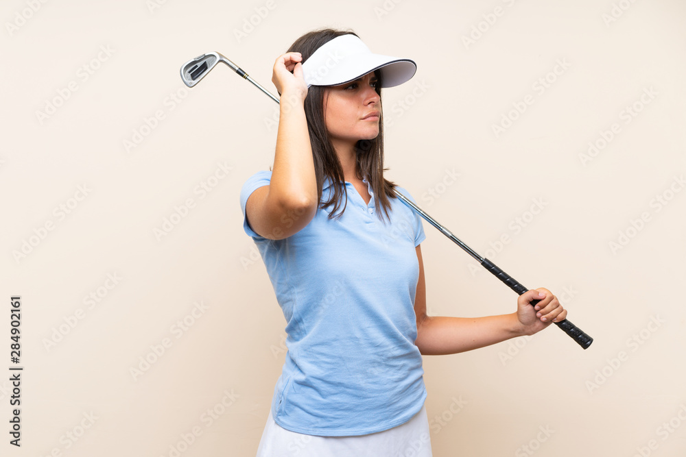 Young golfer woman over isolated background having doubts and with confuse face expression Young golfer woman over isolated background having doubts and with confuse face expression