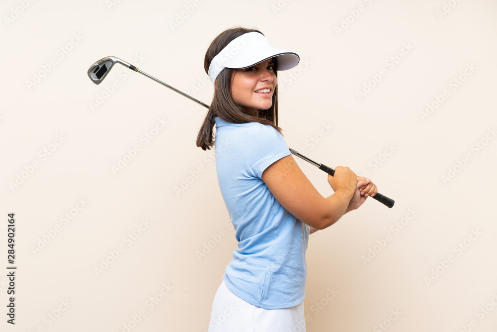 Young golfer woman over isolated background Young golfer woman over isolated background