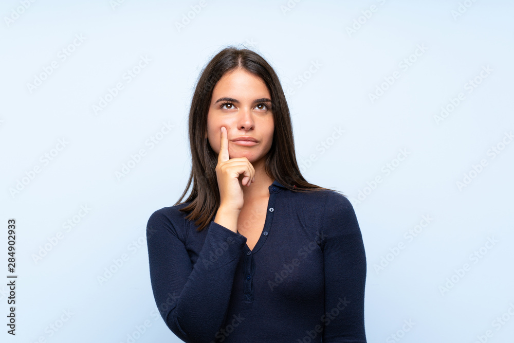 Young girl over isolated blue background thinking an idea Young girl over isolated blue background thinking an idea