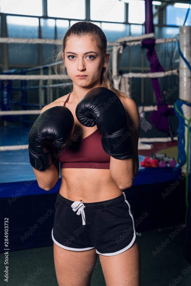 MMA young woman in black boxing gloves