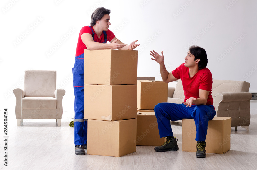 Two young contractor employees moving personal belongings Two young contractor employees moving personal belongings