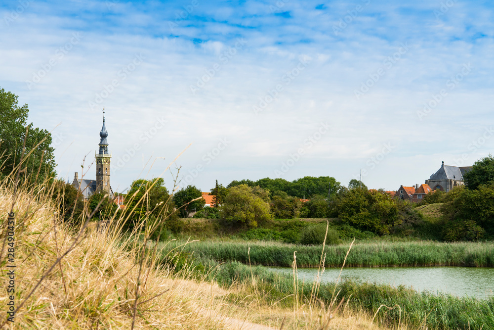 Hiking path along water in Veere, The Natherlands. With view on the Town Hall.