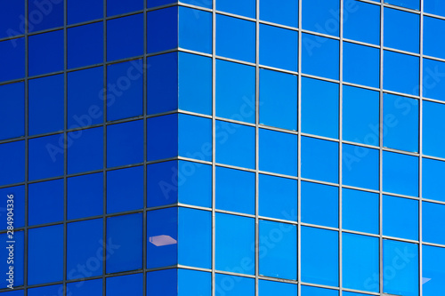 Glass blue square Windows of facade modern city business building skyscraper. Modern apartment buildings in new neighborhood. Windows of a building  texture.