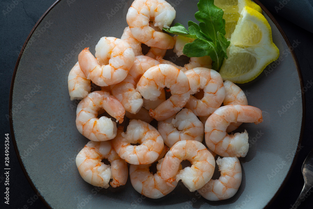 Fresh shrimps in plate over dark background. Healthy food. Top view. Copy space. Fresh shrimps in plate over dark background. Healthy food. Top view. Copy space.