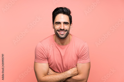 Handsome young man over isolated pink background laughing