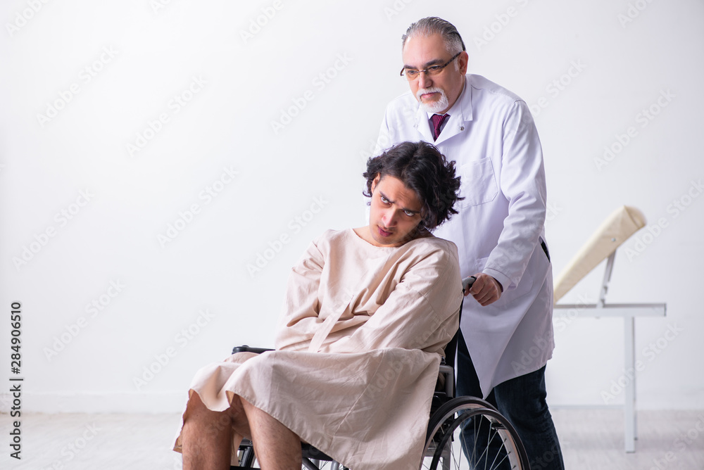 Old male doctor psychiatrist and patient in wheel-chair Old male doctor psychiatrist and patient in wheel-chair