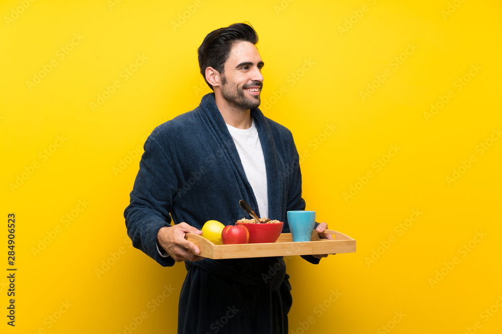 Handsome man in pajamas over isolated yellow wall Handsome man in pajamas over isolated yellow wall