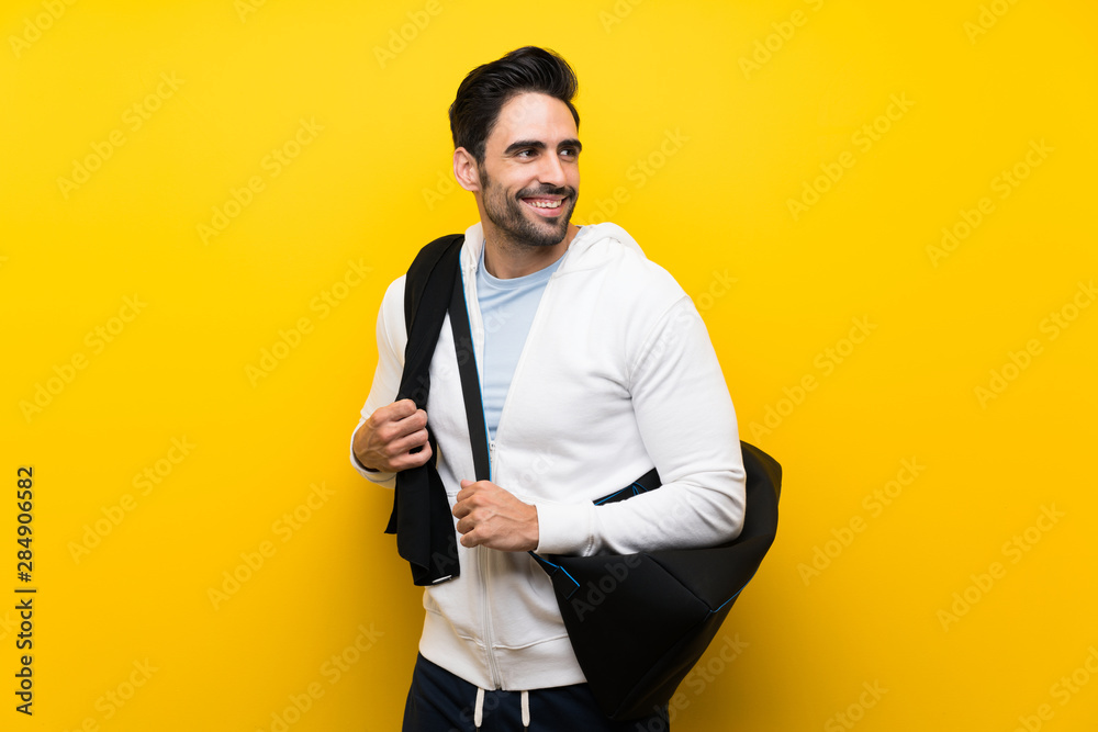 Young sport man over isolated yellow wall Young sport man over isolated yellow wall