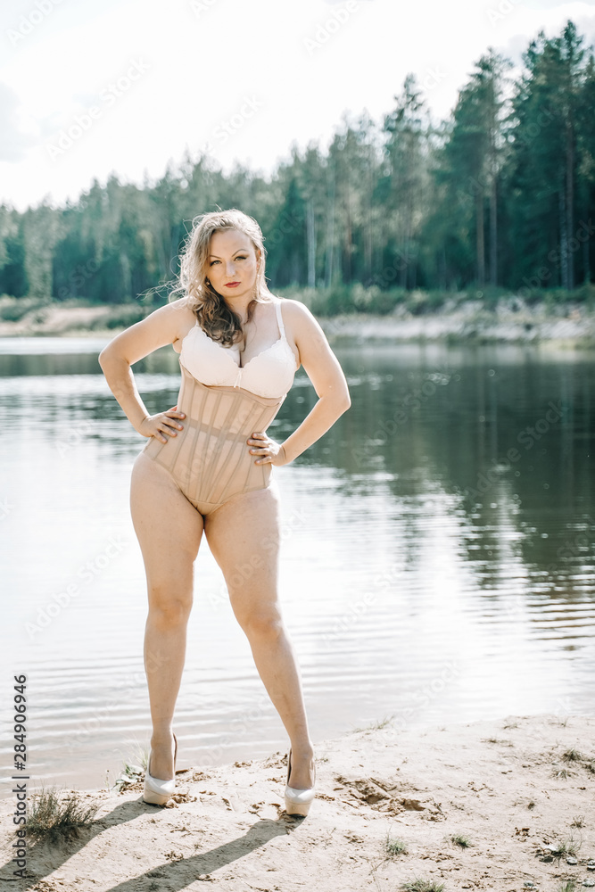 plus size woman with curvy figure in corset lingerie. caucasian xxl chubby  girl wanna swimming. Stock Photo