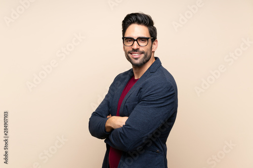 Handsome young man over isolated background with arms crossed and looking forward