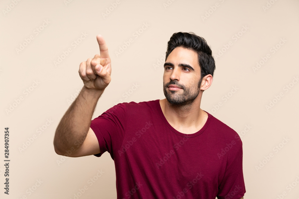 Handsome young man over isolated background touching on transparent screen Handsome young man over isolated background touching on transparent screen