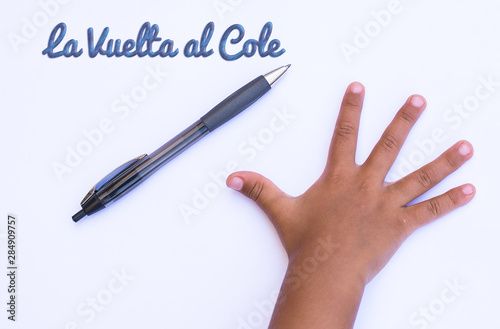 fondo blanco con mano de un niño y un bolígrafo para la vuelta al cole