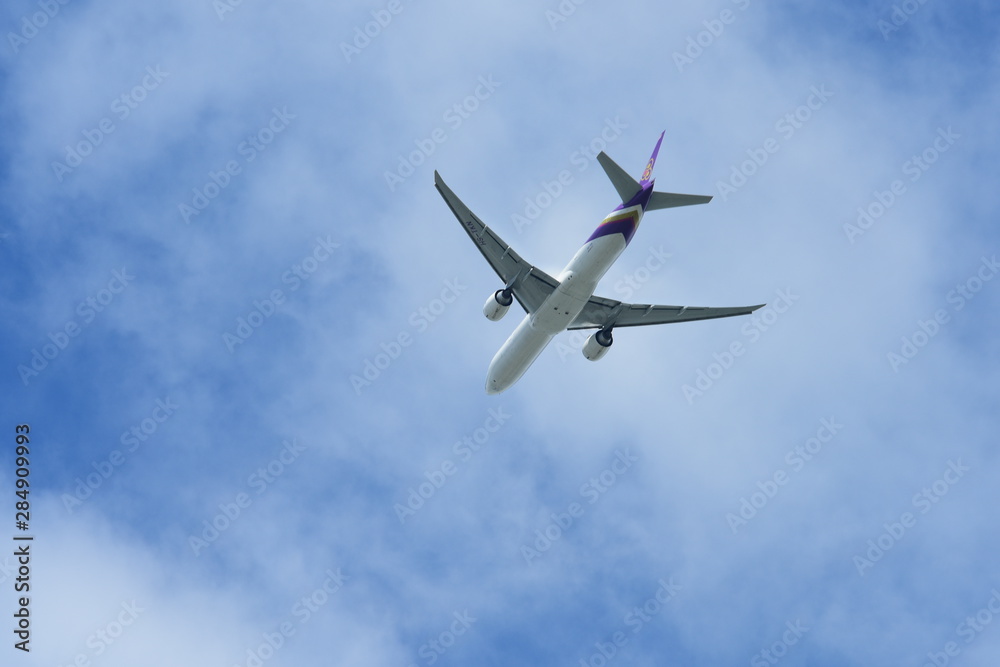 The plane is flying on the blue sky.