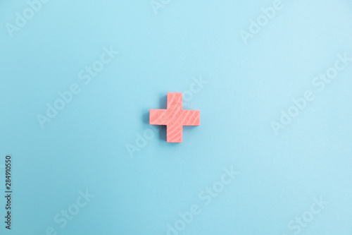 Top view of Pink Plus sign on blue color background