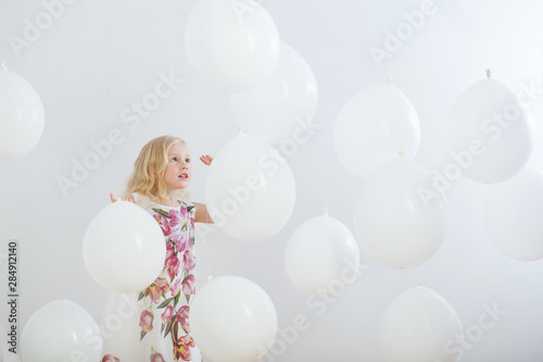 Fototapete little girl with white balloons indoor