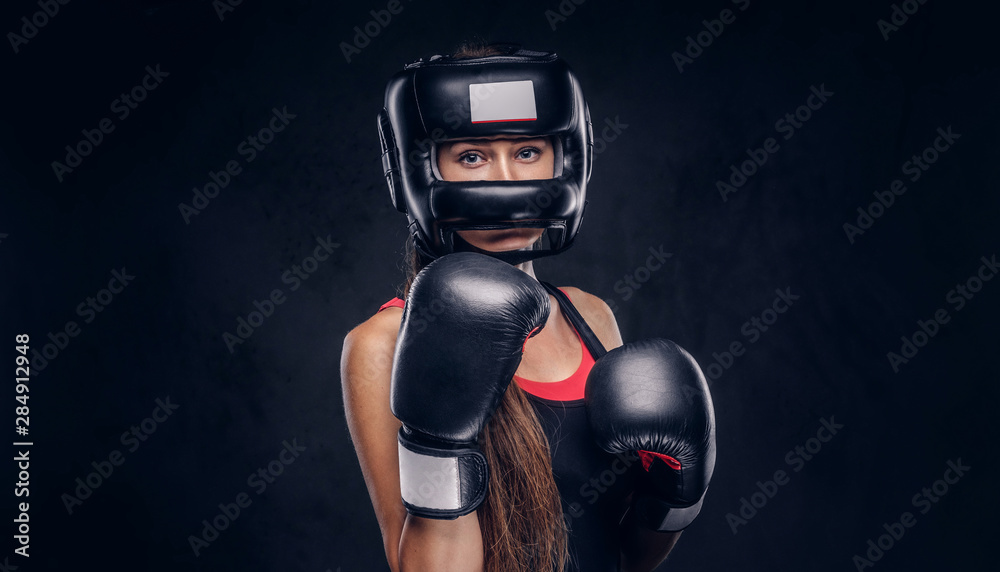 Brave woman is ready to fight, she is wearing boxer gloves and protective helmet.