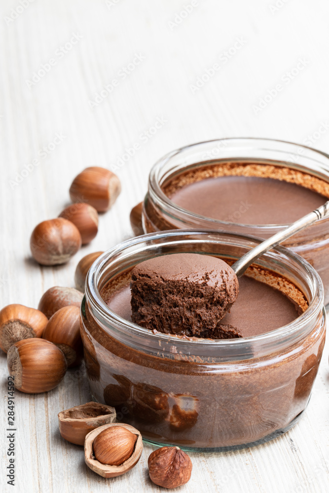 Homemade chocolate hazelnut praline in glass jar on white wooden table Homemade chocolate hazelnut praline in glass jar on white wooden table
