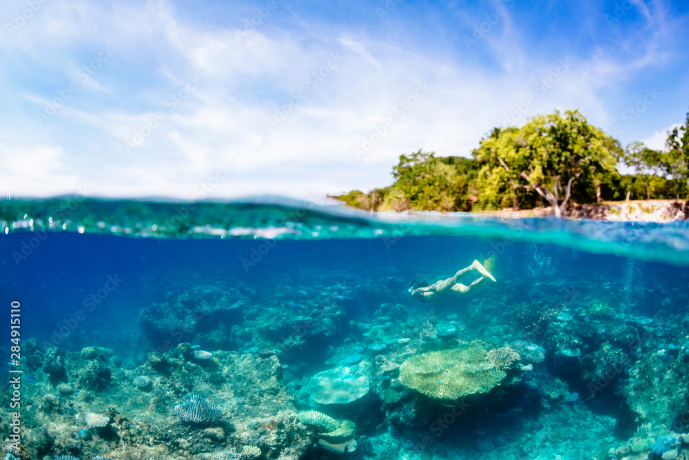 A woman snorkelling over a coral reef off the coast of Espiritu Santo, Vanuatu. A woman snorkelling over a coral reef off the coast of Espiritu Santo, Vanuatu.