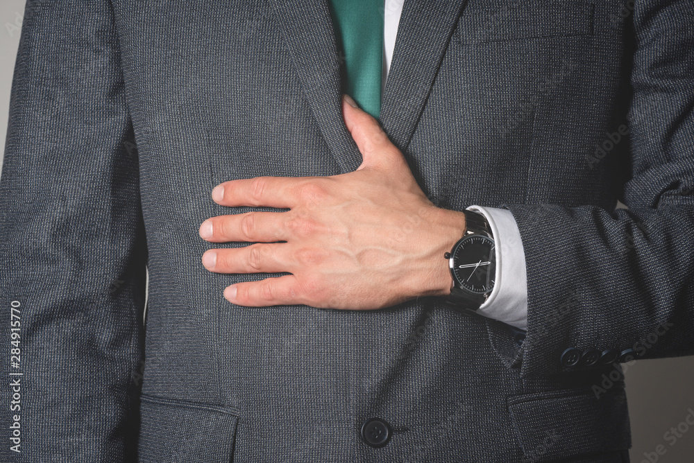 Businessman is wearing a wrist watch close up.