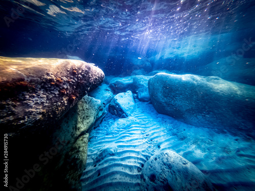 Underwater view of the seabed in San Lorenzo beach  in the southern Sicily  Italy. The shot is takend during a sunny summer day  with rays of light coming inside the water