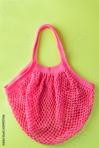 Coral string bag on a light green background. Zero waste concept.