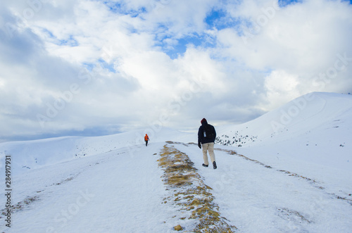 People climbing in Carpathian mountains in winter, covered with snow