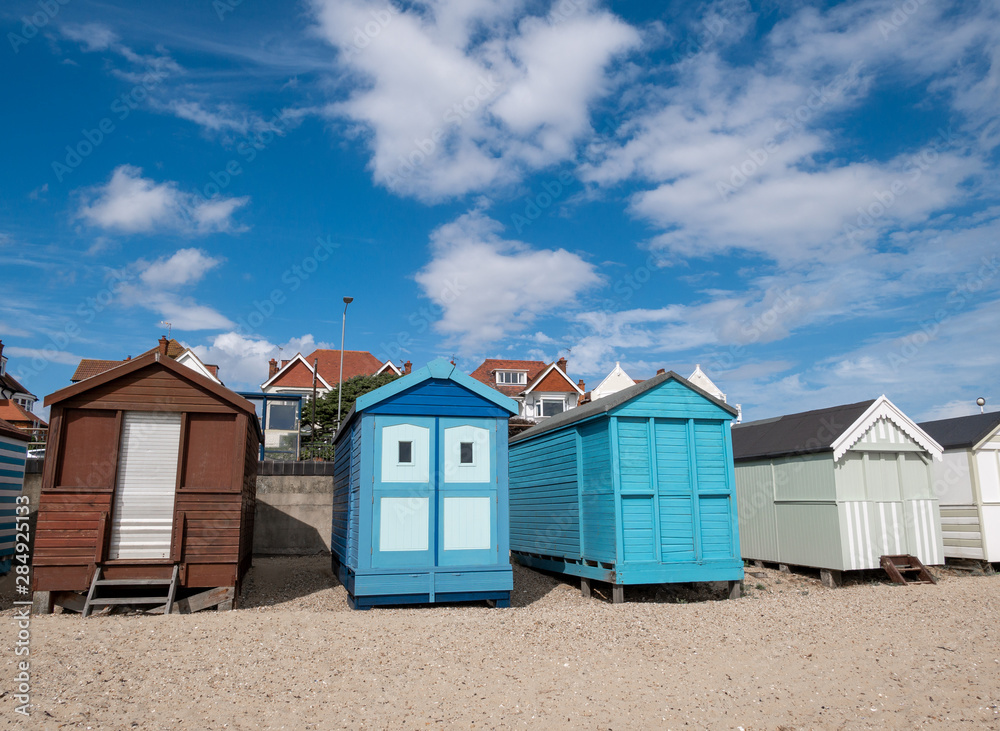 Traditional wooden huts houses on the beach against blue sky and clouds in Southend on asea