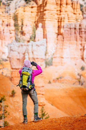 A woman is photographing the scenery while hiking the Fairyland Loop Trail, Bryce Canyon National Park. photo