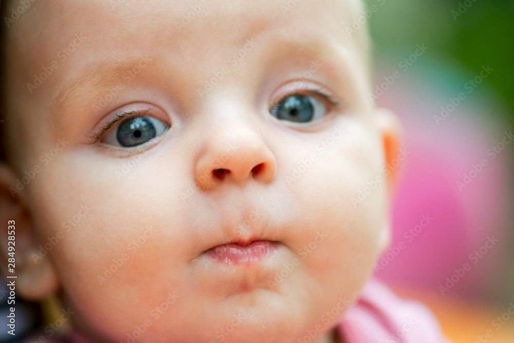Baby portrait. Closeup face with bright blue eyes. Adorable baby