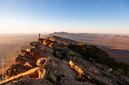 Woman standing on cliff at St Mary Peak during sunrise photo