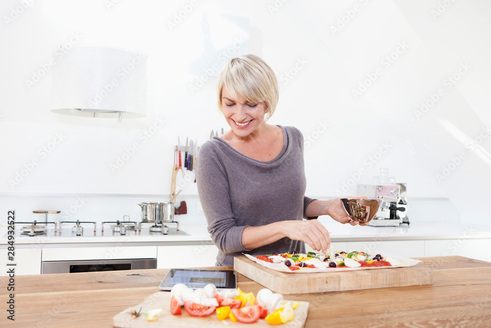 Germany, Bavaria, Munich, Woman preparing pizza in kitchen Germany, Bavaria, Munich, Woman preparing pizza in kitchen