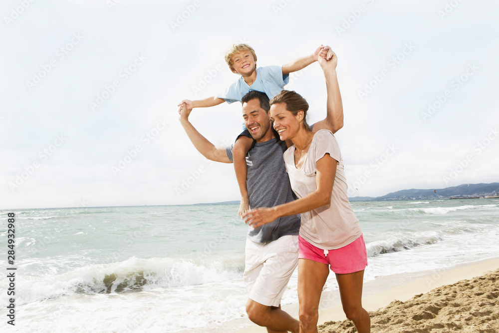 Spain, Family walking on beach at Palma de Mallorca, smiling Spain, Family walking on beach at Palma de Mallorca, smiling