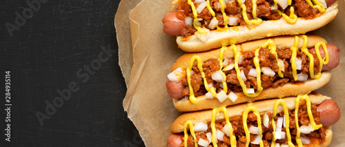 Obraz na płótnie Homemade Detroit style chili dog on a black background, top view