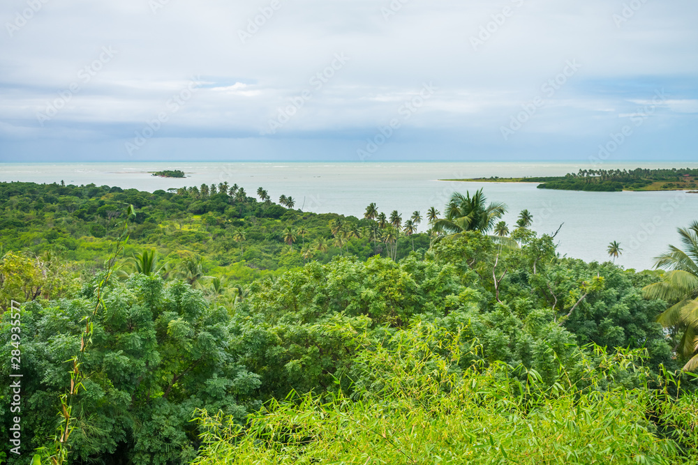 Obraz premium A view of the Atlantic Forest and Atlantic Ocean from the viewpoint in Vila Velha on a rainy day - Itamaraca Island, Brazil