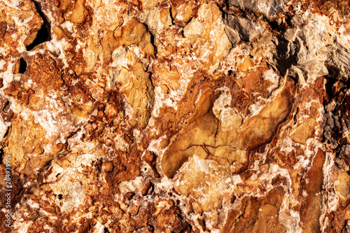 view of orange color sedimentary rocky surface of the riverbank full frame image