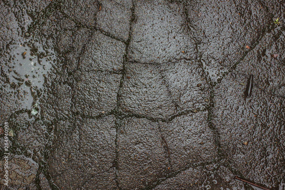 Old asphalt in cracks in the rain Old asphalt in cracks in the rain