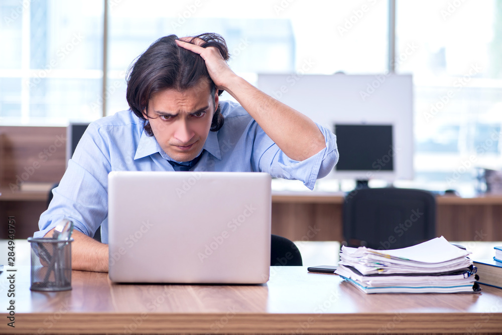 Young employee unhappy with excessive work Young employee unhappy with excessive work